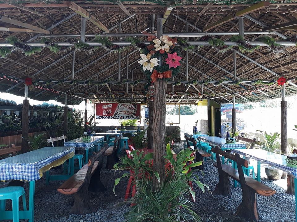 Outdoor tables of the restaurant behind the famous "wishing tree" of Pasuquin